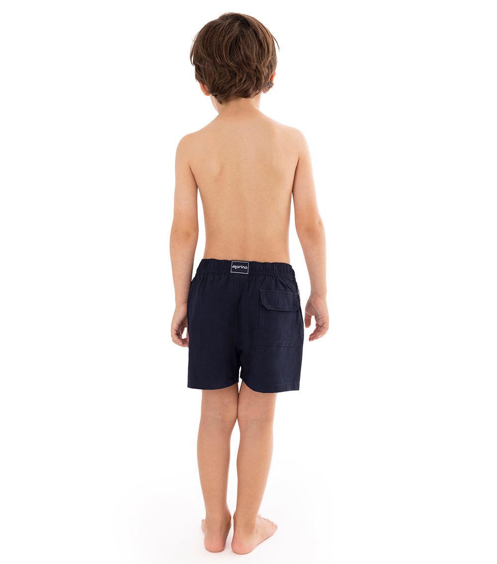 Navy Young boy wearing navy swim shorts on a white background