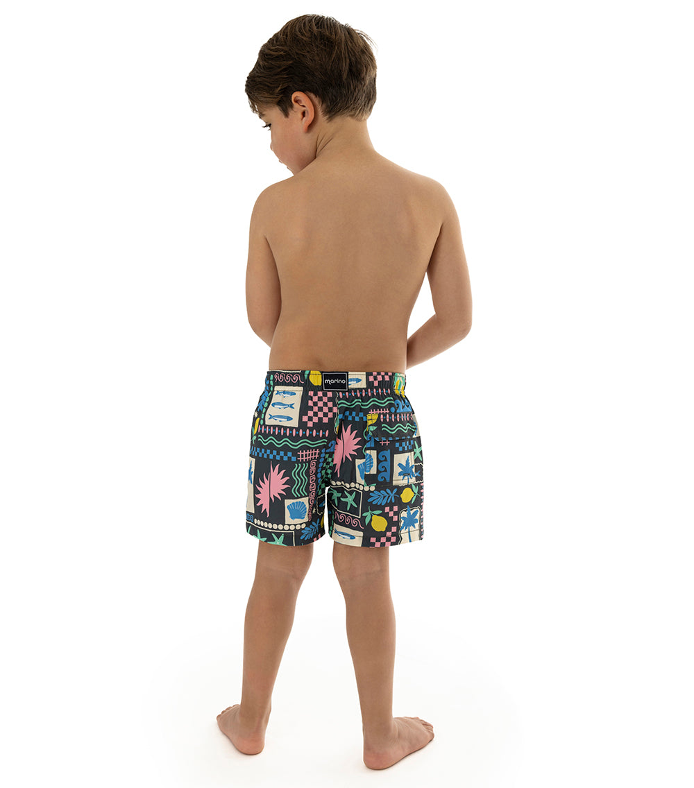 Capri Black Child wearing colorful patterned swim shorts on a white background