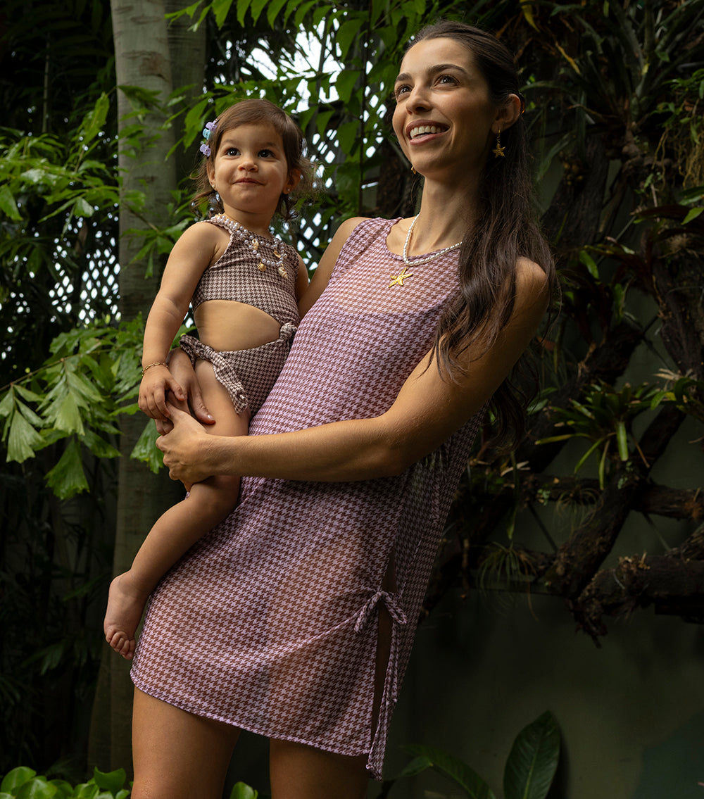 houndstooth Woman and child in matching brown patterned dresses standing among green foliage