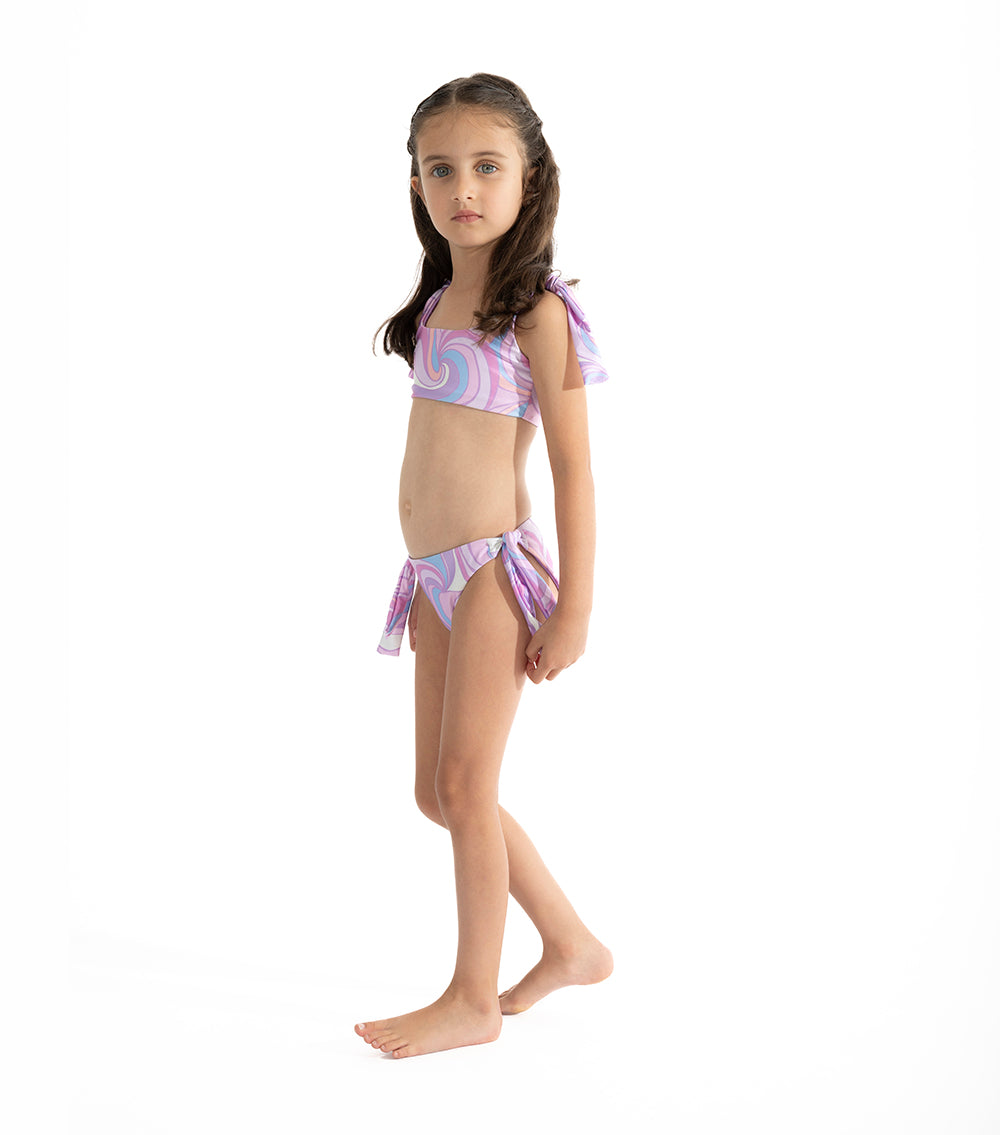 Groovy girl wearing a purple tie-dye bikini on a white background