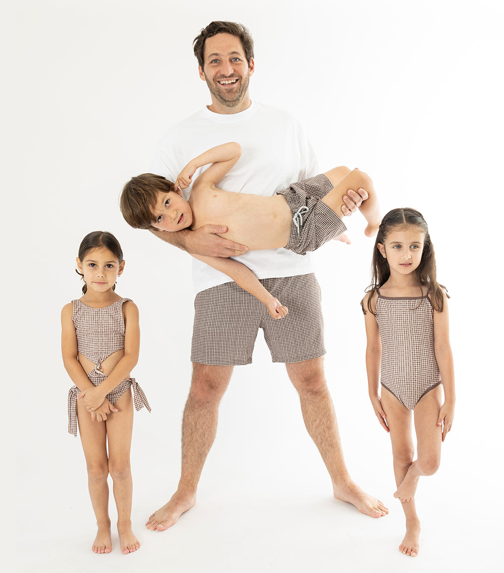 Houndstooth Family of father daughters and son matching brown swimsuits on a white background