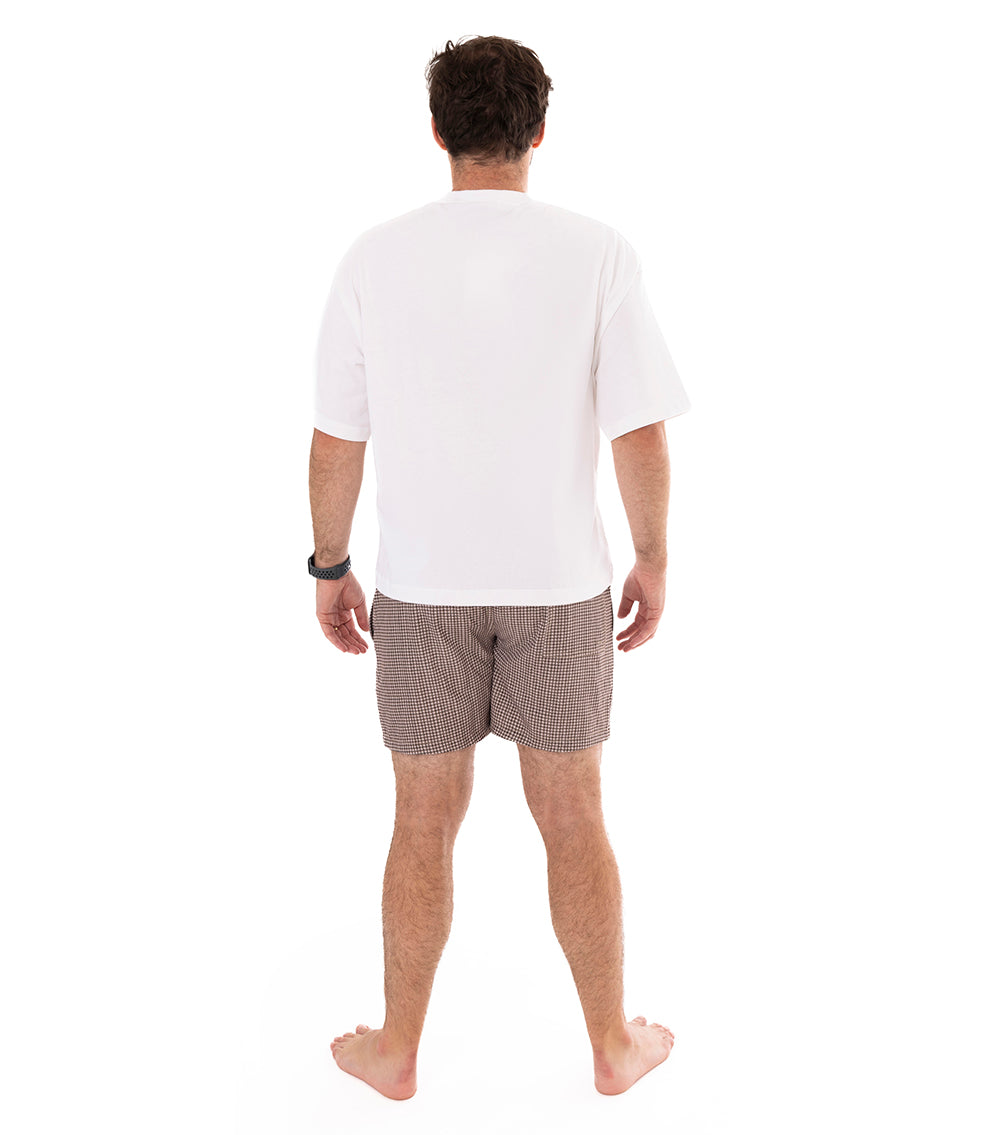 Houndstooth Man wearing brown printed swim shorts