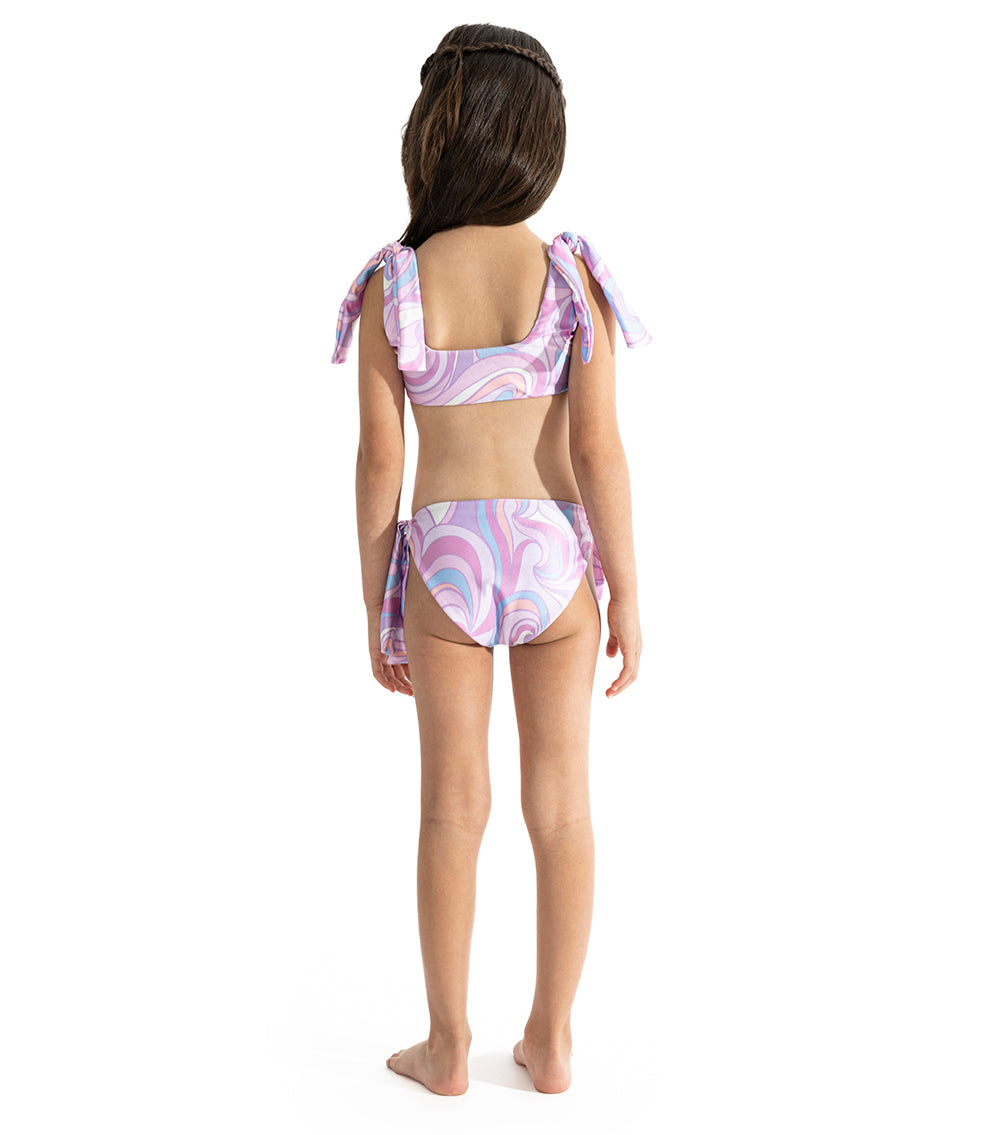 Groovy Young girl wearing a purple and white patterned two-piece swimsuit on a white background