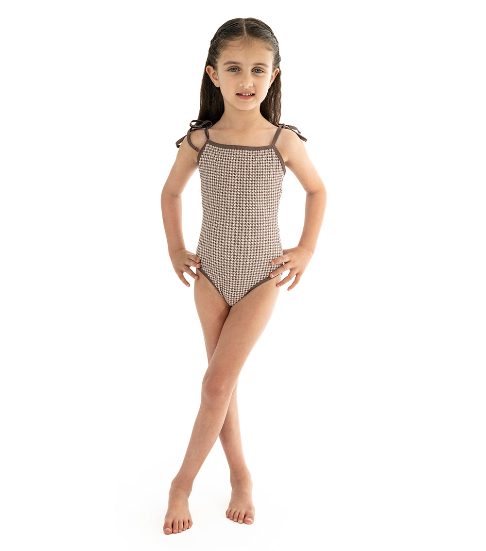 Houndstooth young girl wearing a brown printed swimsuit on a white background
