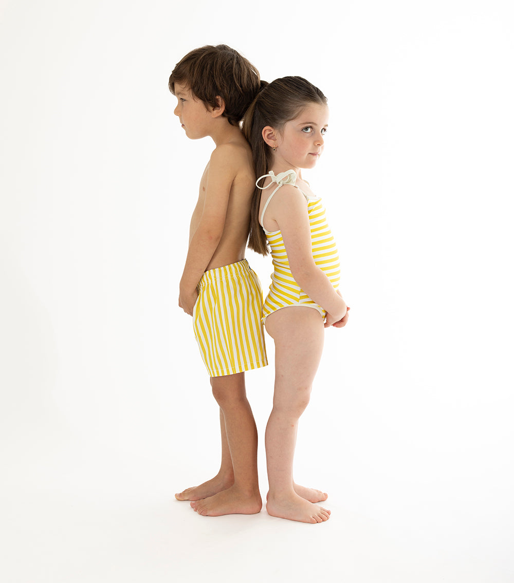 yellow stripes Two children wearing yellow striped swimwear on a white background