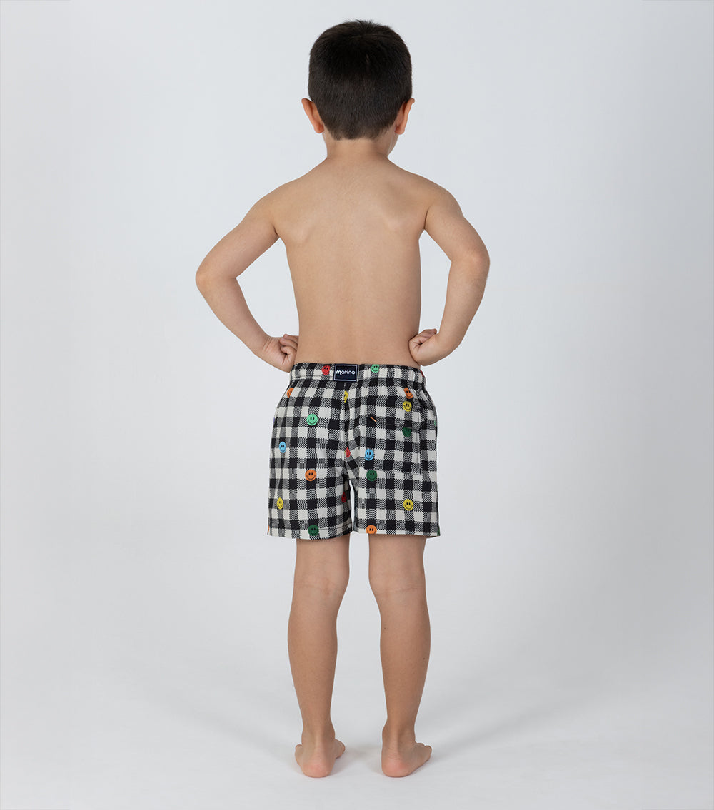 gingham emoji Child wearing black checkered shorts with colorful patterns on a white background