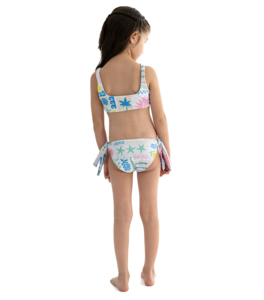 Capri White Young girl wearing a colorful swimsuit with a white background