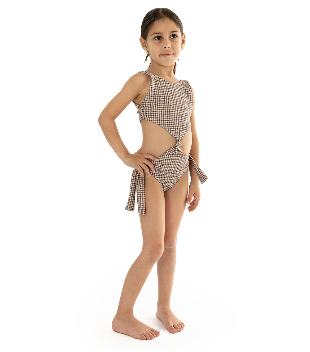 Houndstooth Young girl wearing a brown printed swimsuit on a white background