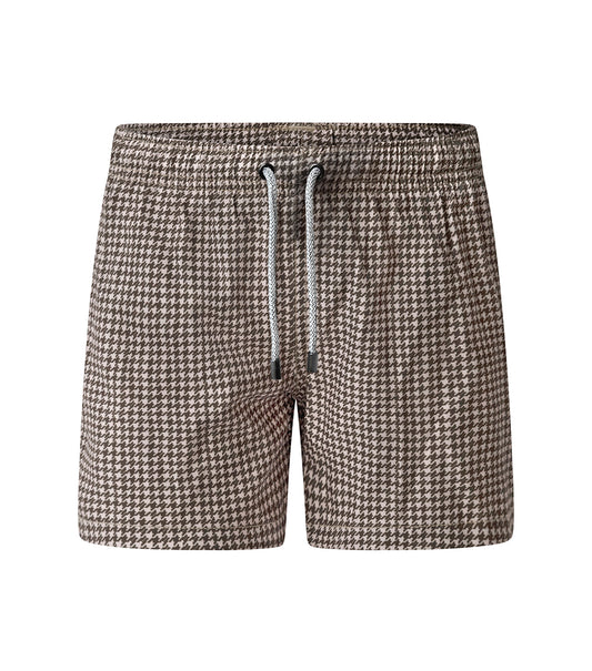 Houndstooth Man wearing brown printed swim shorts