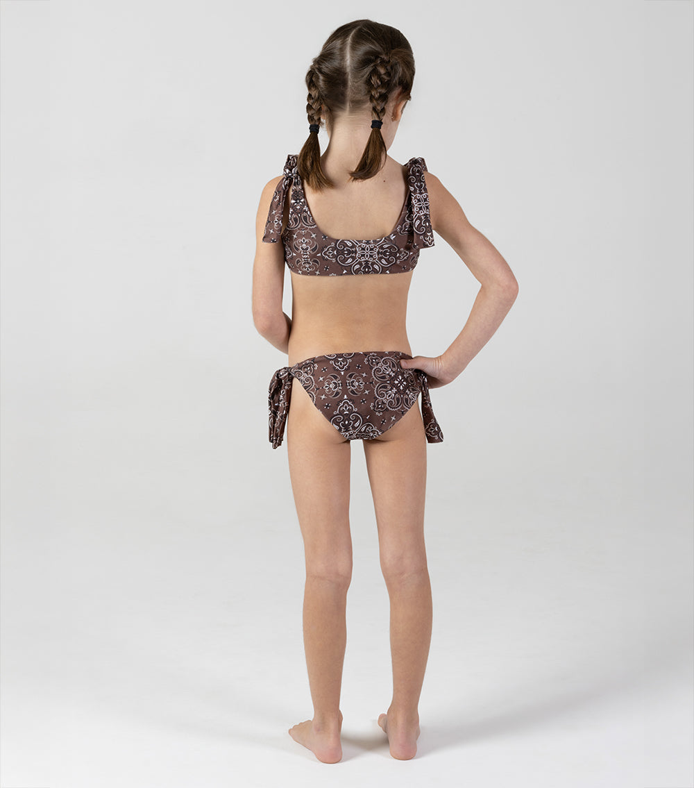 brown bandana Young girl wearing a patterned bikini set on a white background