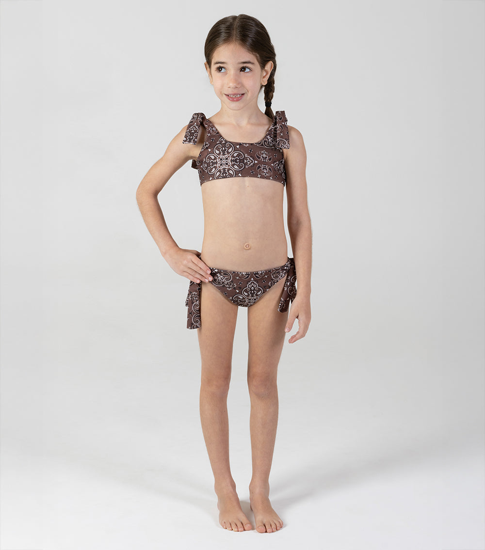 brown bandana Young girl wearing a patterned bikini set on a white background