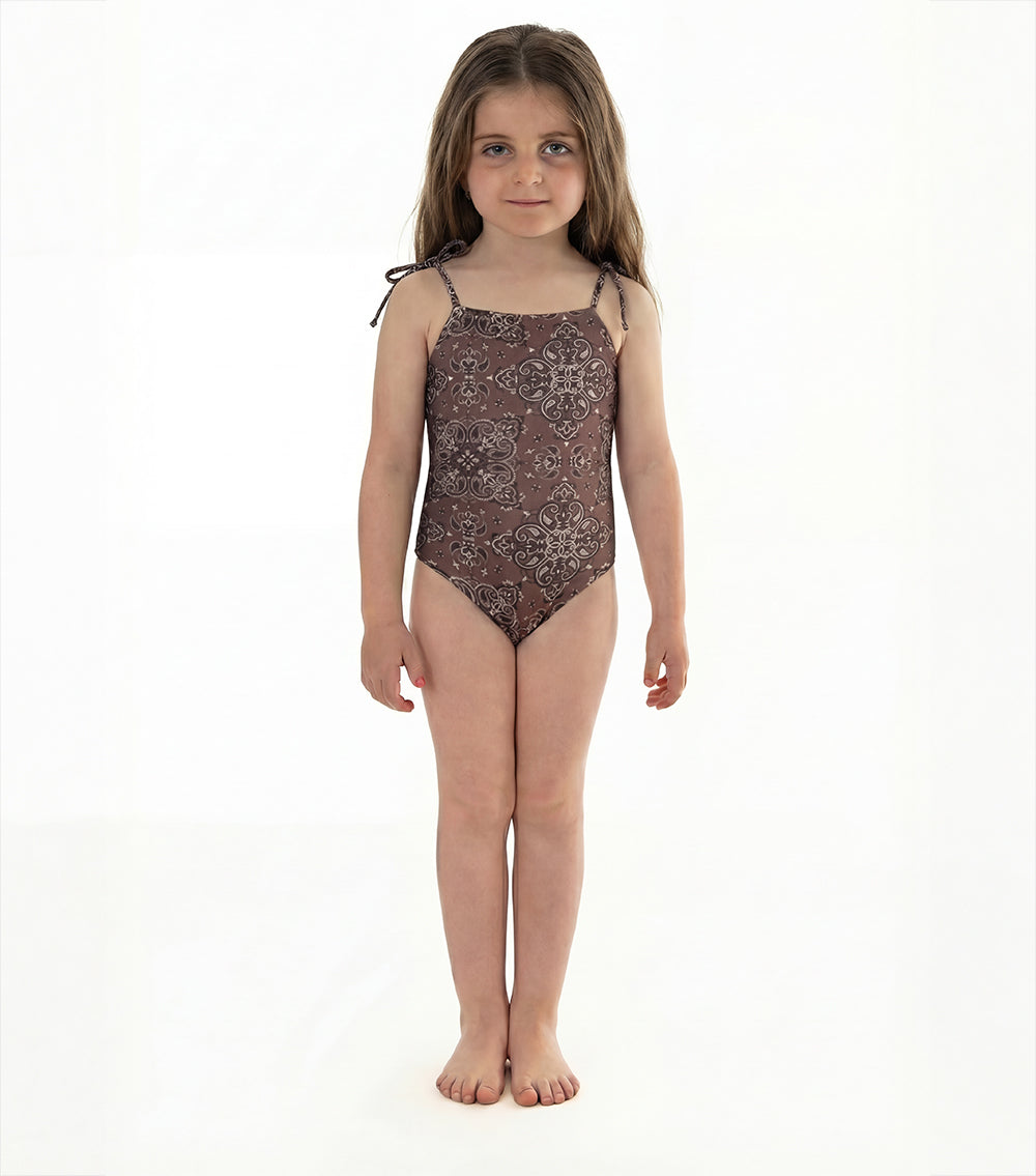brown bandana Young girl wearing a patterned swimsuit on a white background
