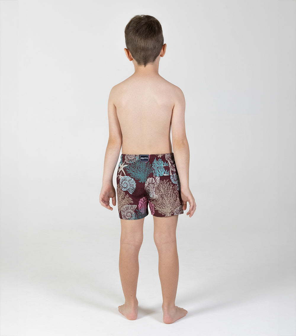 burgundy corals Child wearing patterned shorts on a white background