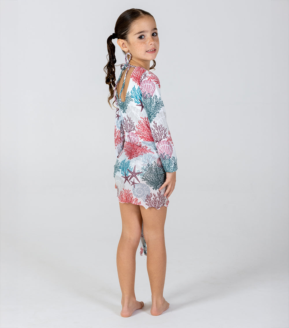 ivory corals Young girl wearing a floral dress with long sleeves on a white background