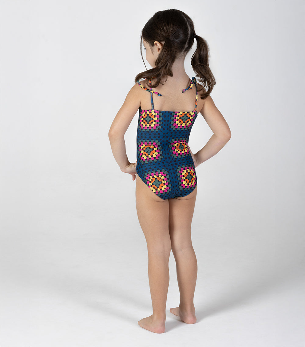crochet Child wearing a colorful patterned swimsuit on a white background