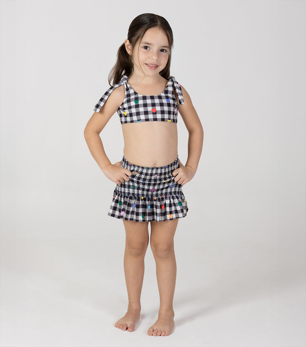 gingham emoji Young girl wearing a checkered bikini set on a white background