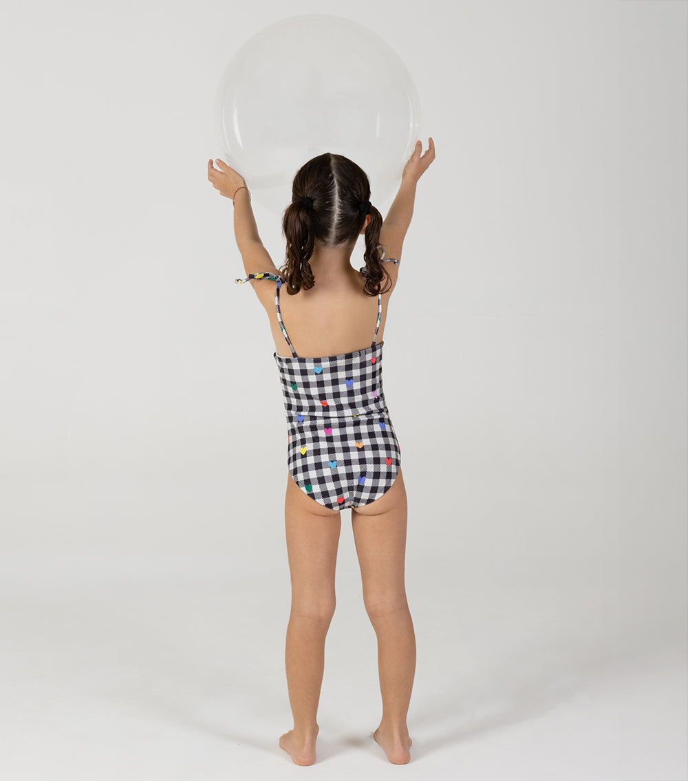 gingham emoji Child wearing a checkered swimsuit against a white background