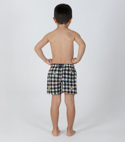 gingham emoji Child wearing black checkered shorts with colorful patterns on a white background