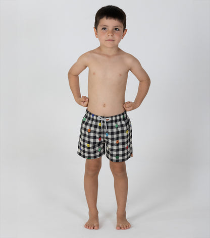 gingham emoji Young boy wearing black and white checkered shorts with colorful buttons on a white background