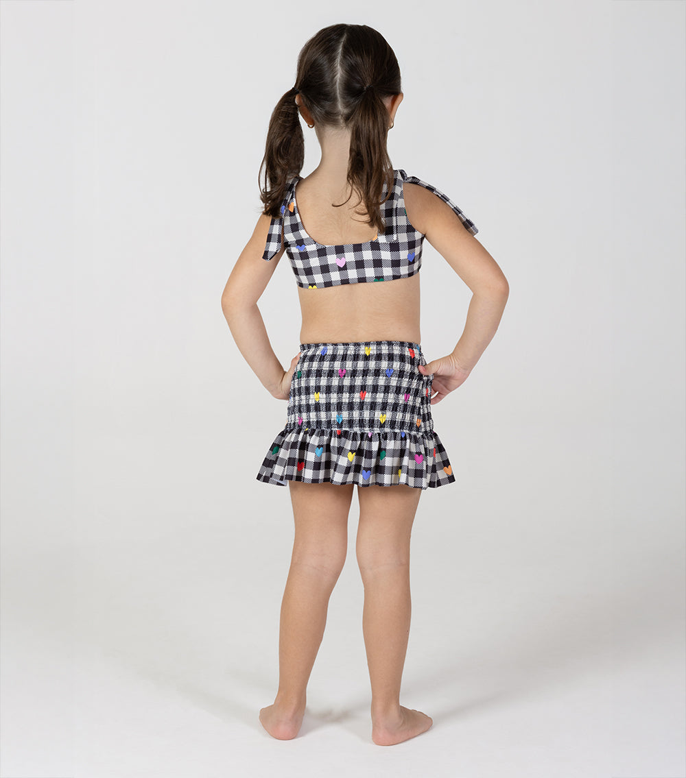 gingham emoji Young girl wearing a checkered outfit with colorful polka dots on a white background