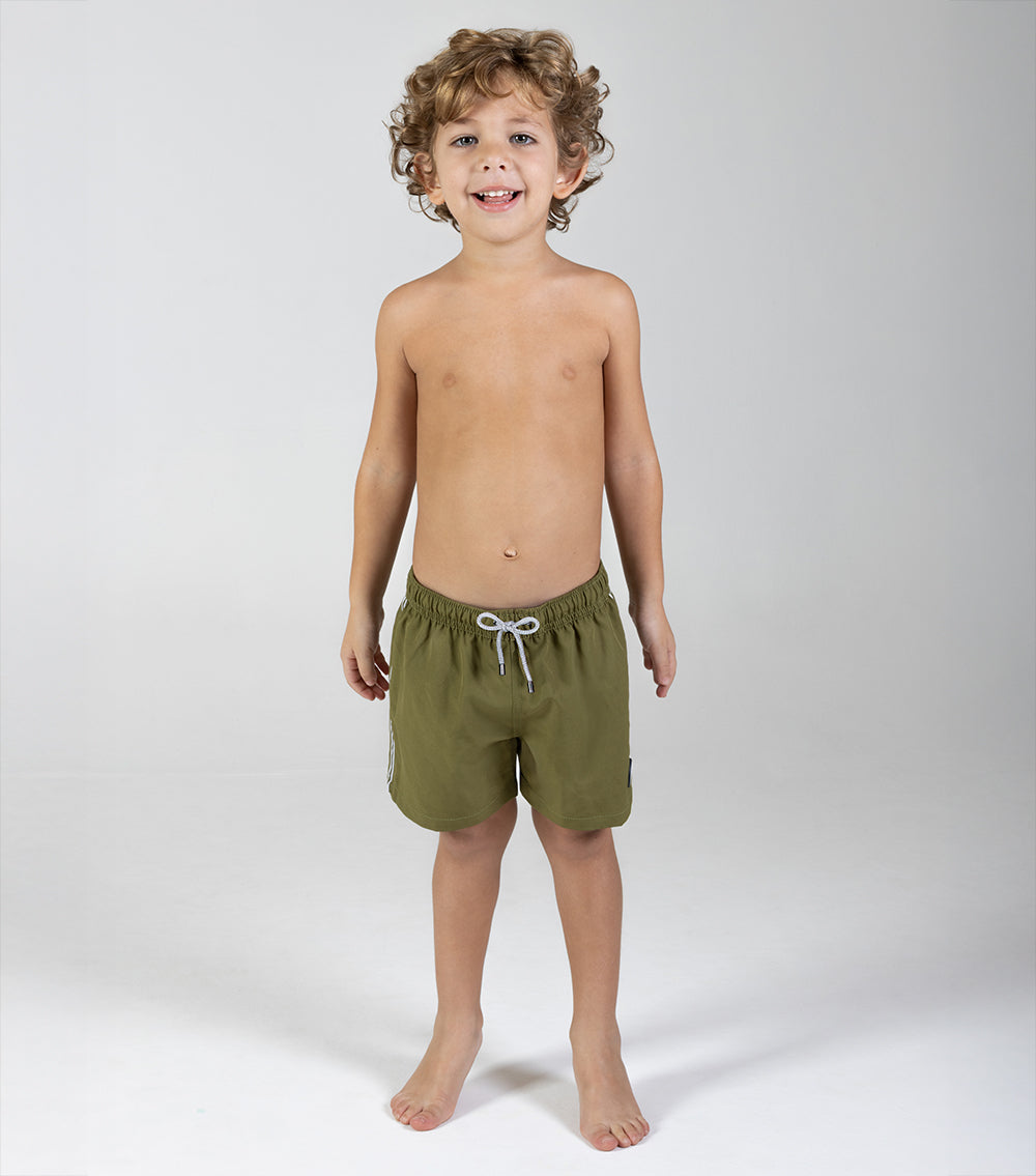 olive green Child wearing green shorts on a white background