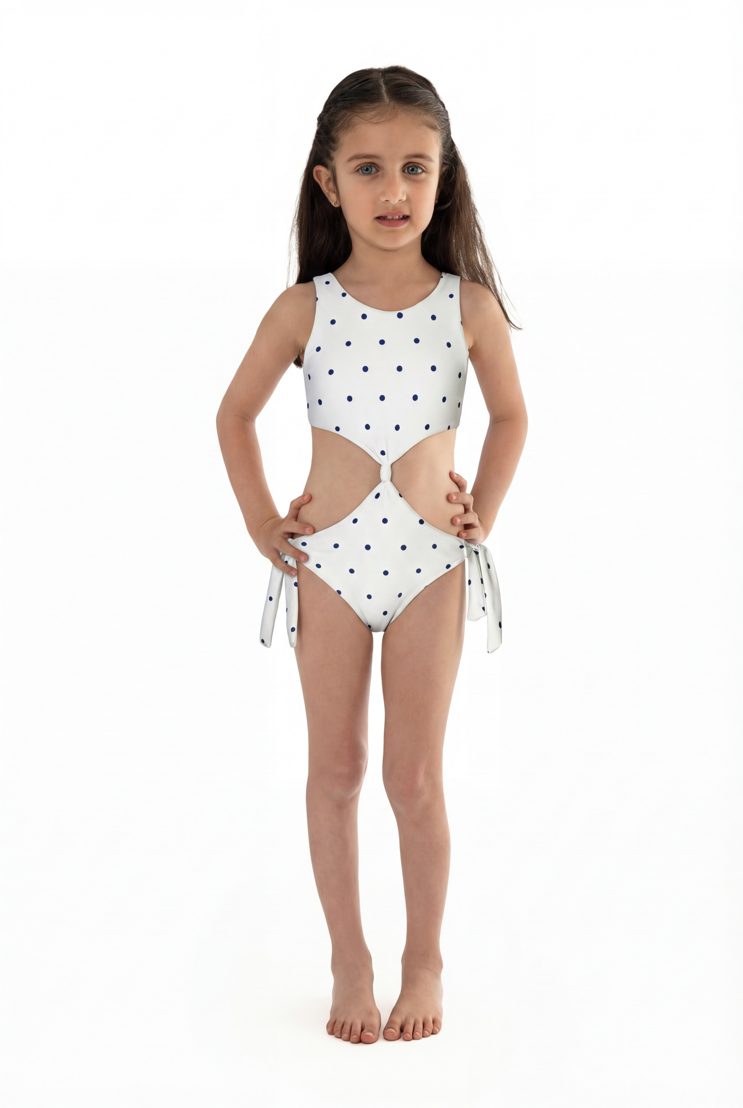 polka dots white Young girl wearing a white swimsuit with black polka dots on a white background