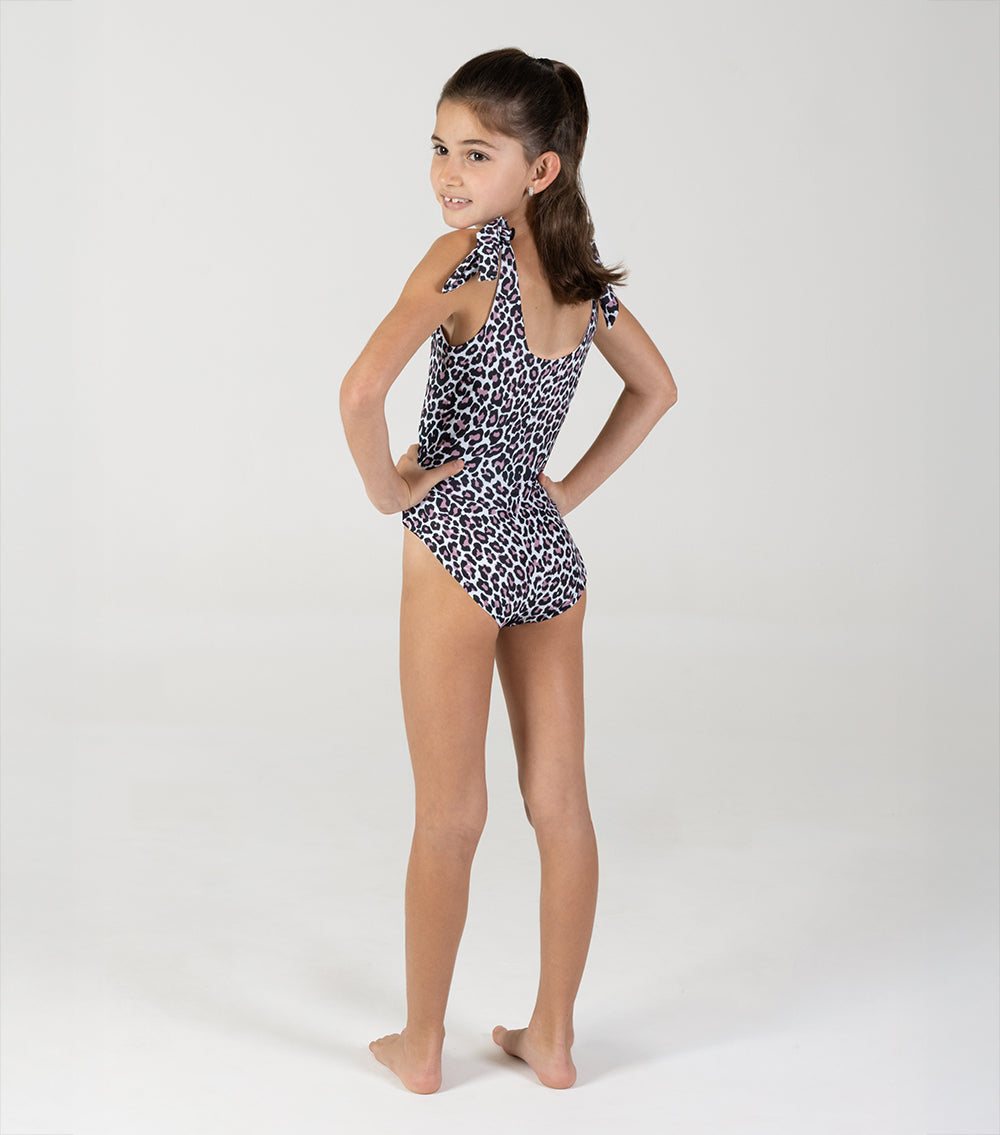 Leopard Young girl wearing a leopard print swimsuit on a white background