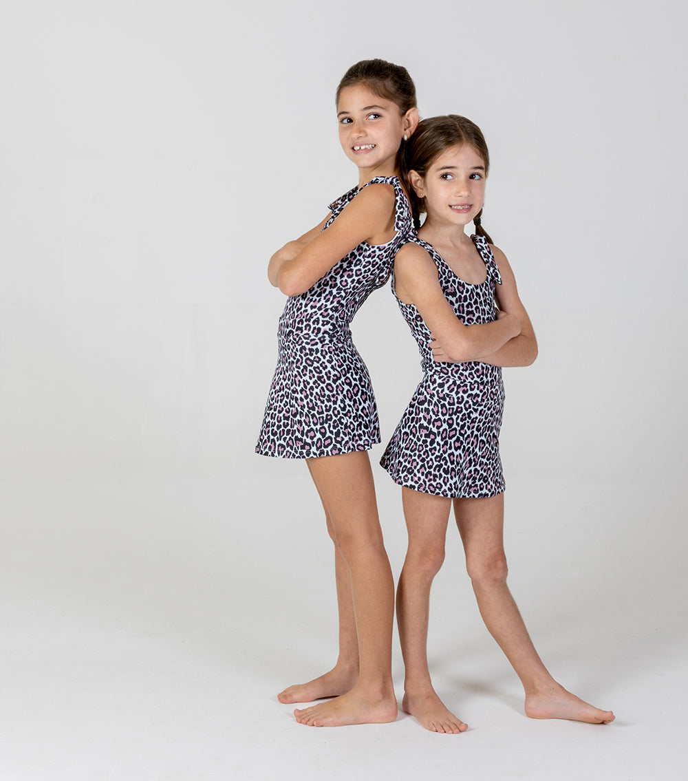 leopard Two young girls wearing matching leopard print outfits on a white background