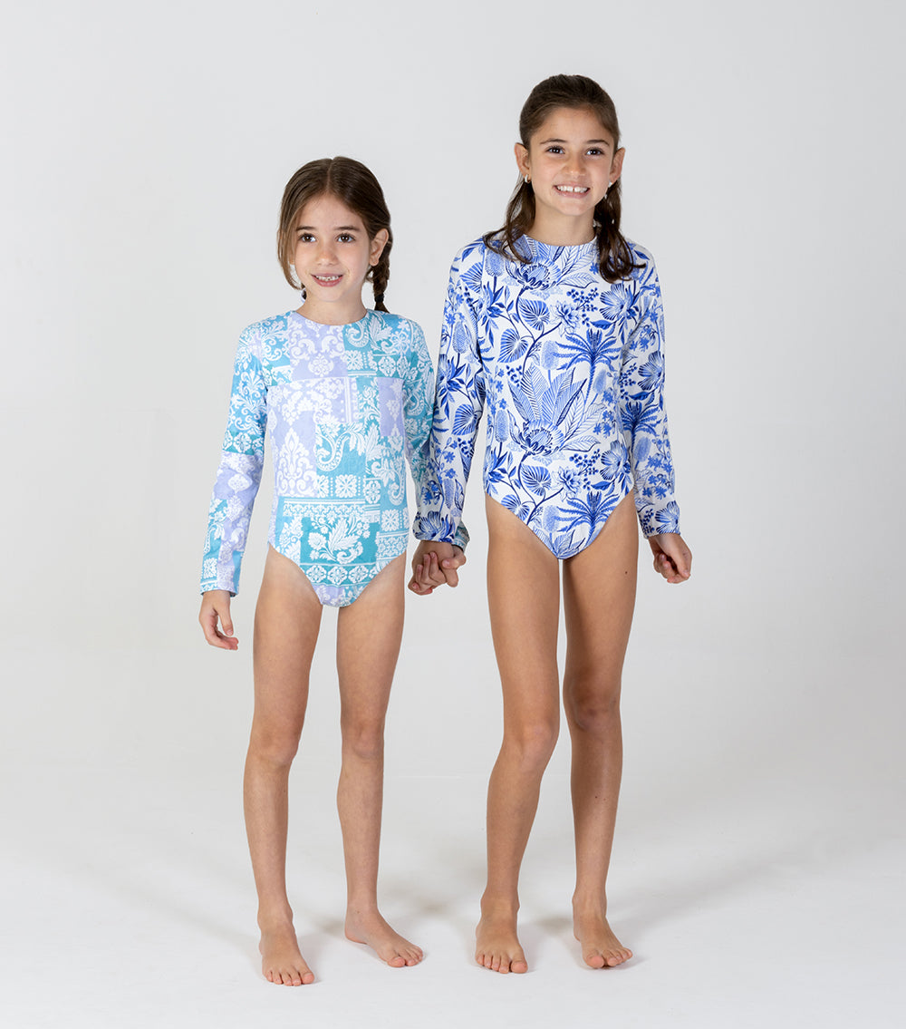 paisley tropical Two children wearing matching blue floral swimsuits on a white background