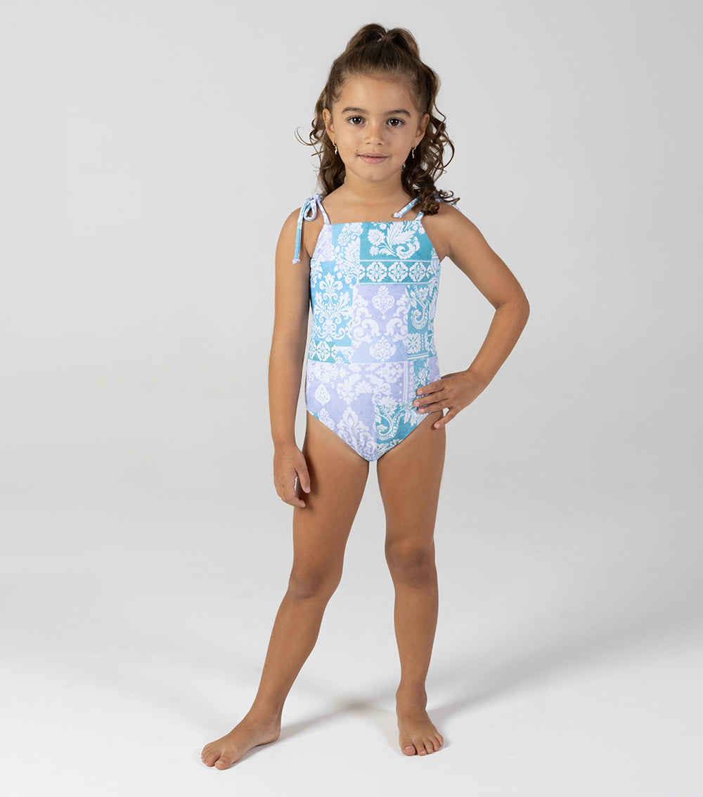 paisley Young girl wearing a blue floral swimsuit on a white background