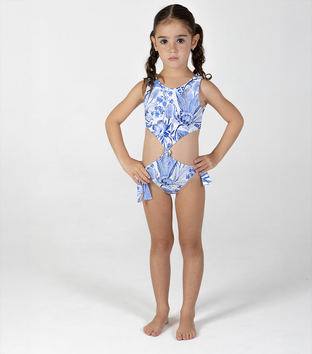 tropical Young girl wearing a blue floral swimsuit on a white background